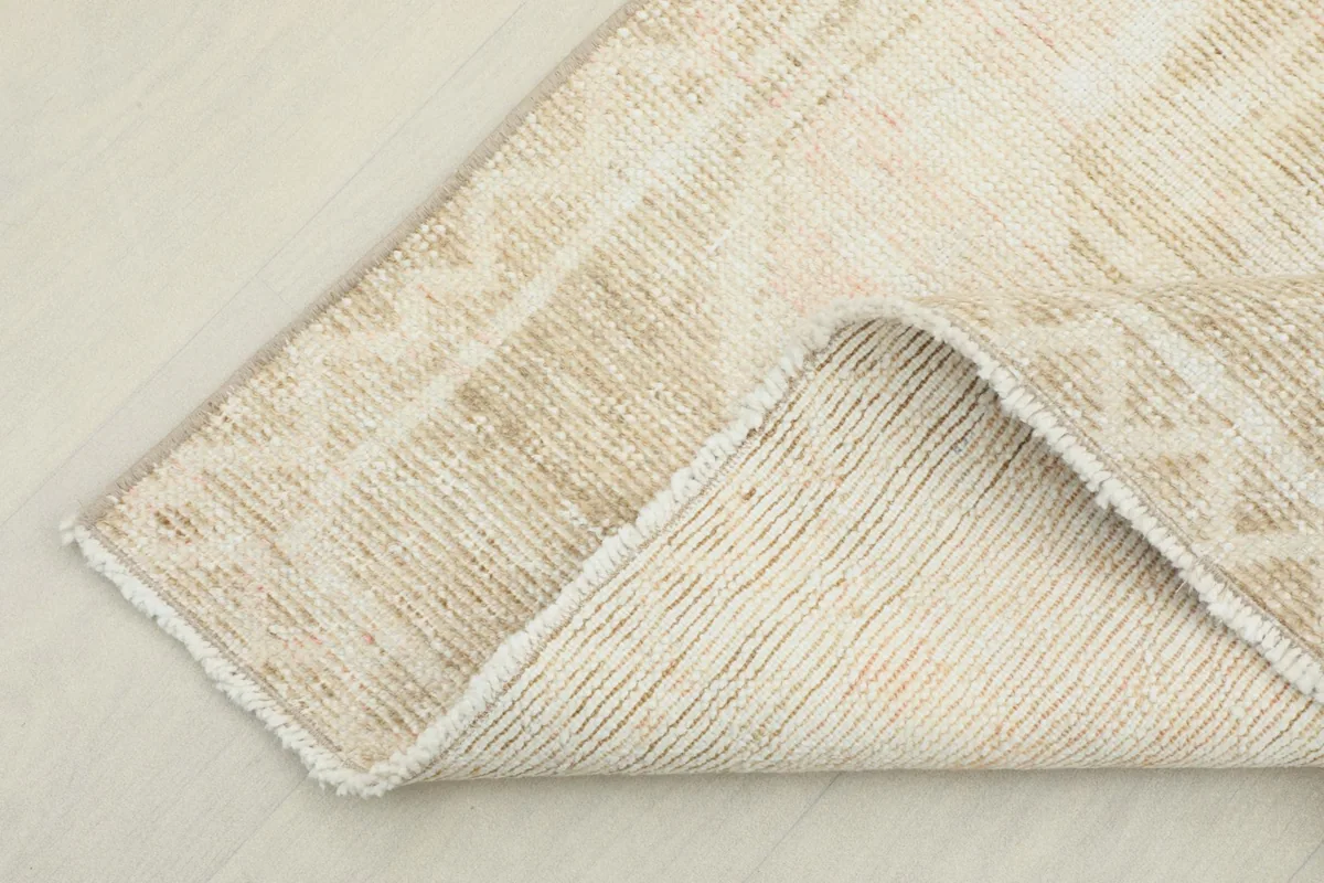 Corner of the runner flipped to show the back of the hand-knotted cotton foundation and fringe