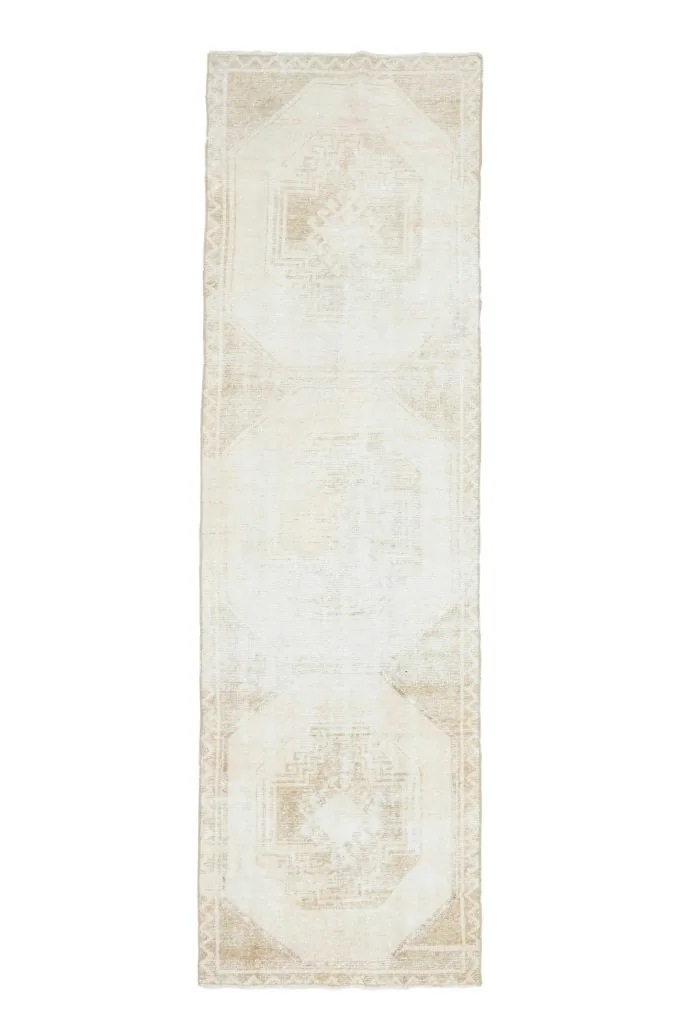 Full overhead view of the beige and tan vintage runner rug, displaying its entire geometric design
