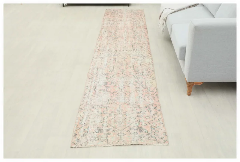 Full overhead view of the vintage rose tribal geometric runner rug on a white floor