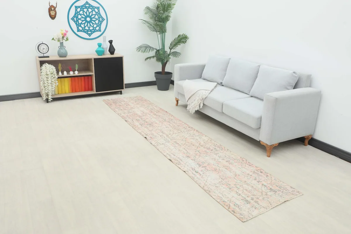 Vintage runner rug laid out in a modern room with a light gray sofa and side table
