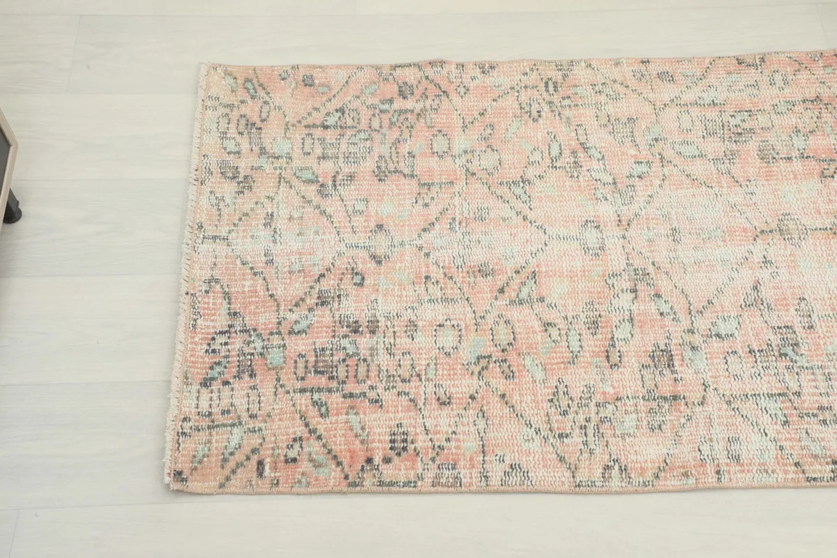 Detailed view of the distressed rose and gray patterns with visible wool texture