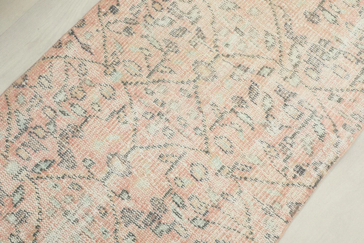 Macro shot highlighting the faded rose and gray colors and hand-knotted wool pile