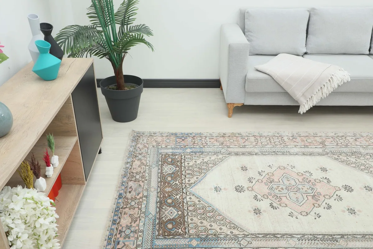 Angle view of the rug in a room, showing its placement in front of a sofa and a plant.