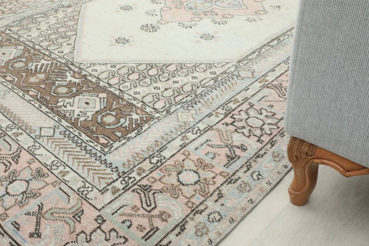 Partial view of the rug next to a chair leg, showing its integration into a home decor setting.
