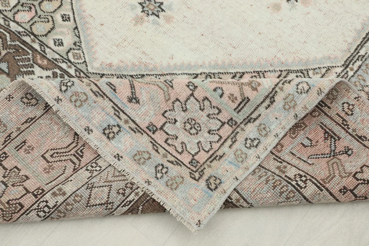 Corner of the rug folded to show the reverse side and the hand-knotted construction.
