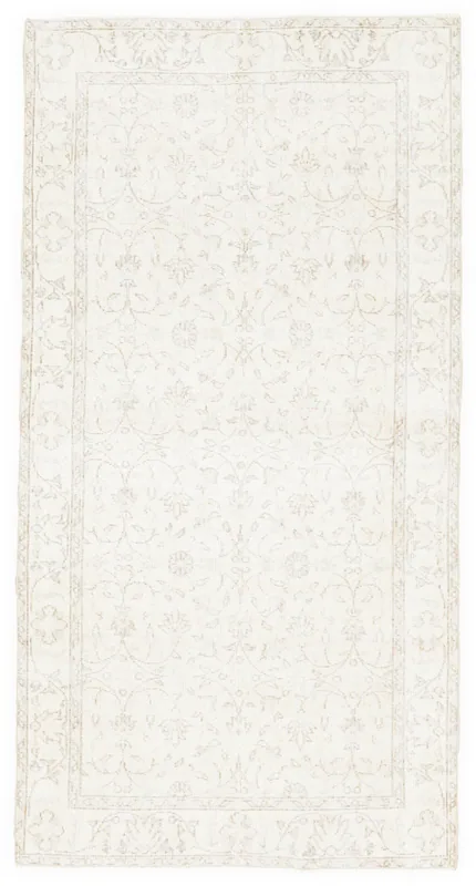 Full top view of the 3'8" x 7'1" ivory and beige floral vintage Anatolian area rug on a white background