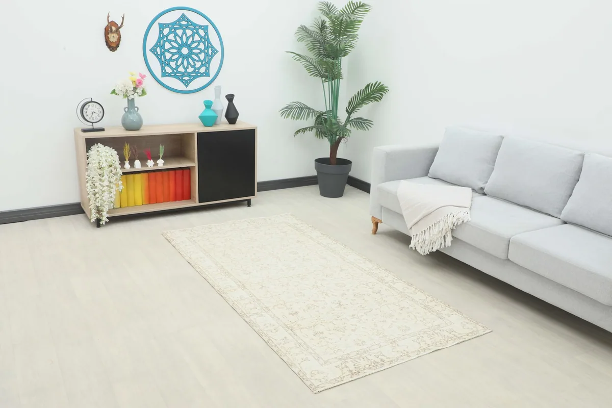 Ivory and beige floral vintage Anatolian area rug displayed in a bright living room setting