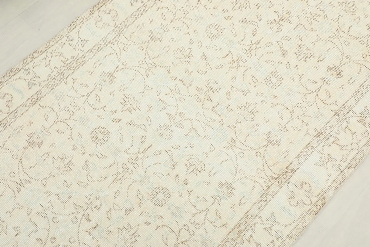 Overhead view focusing on the central floral motifs and subtle color variations of the vintage Anatolian rug