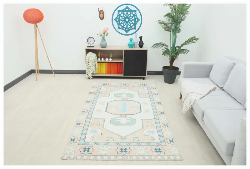Full top view of the ivory, rose, and blue geometric vintage Anatolian rug on a white background