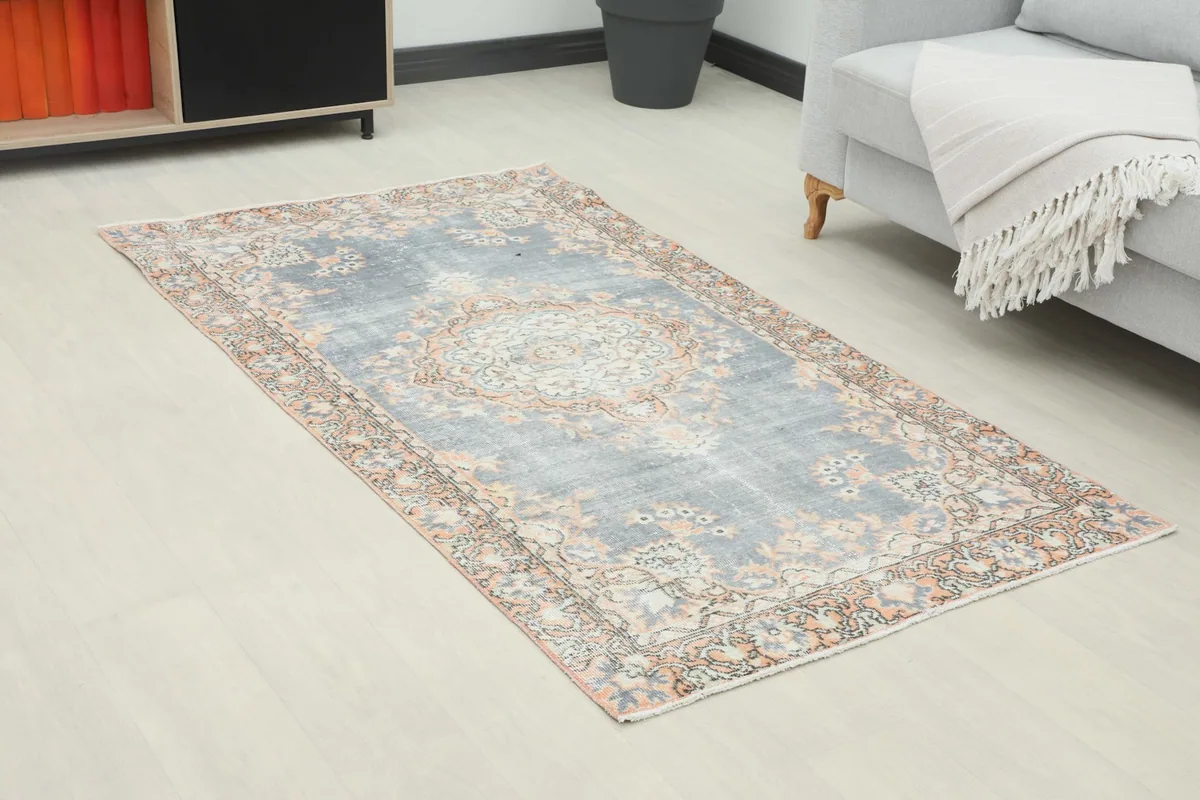 Angle view of the gray and orange vintage rug placed in a modern room