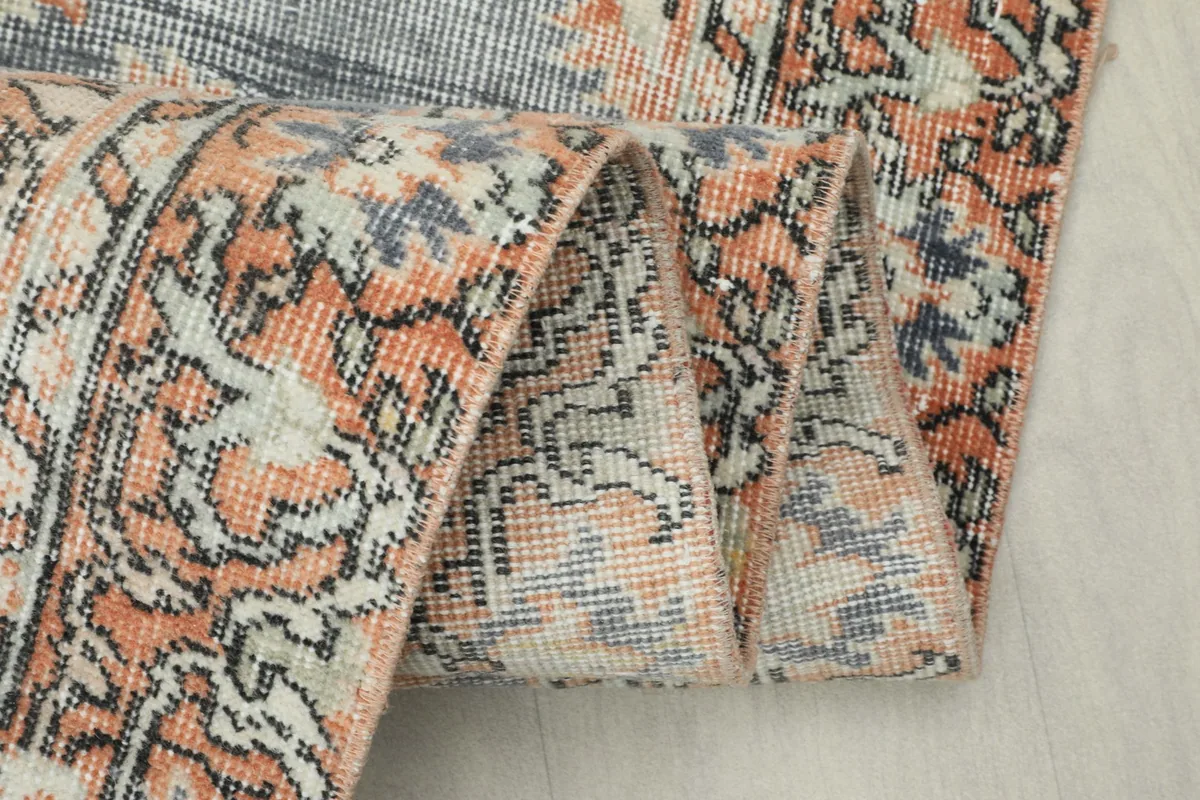 Close-up of the rug's low wool pile texture and distressed appearance