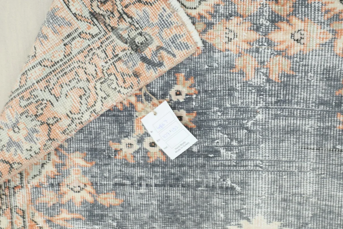 View of the rug's reverse side and hand-knotted construction with a tag