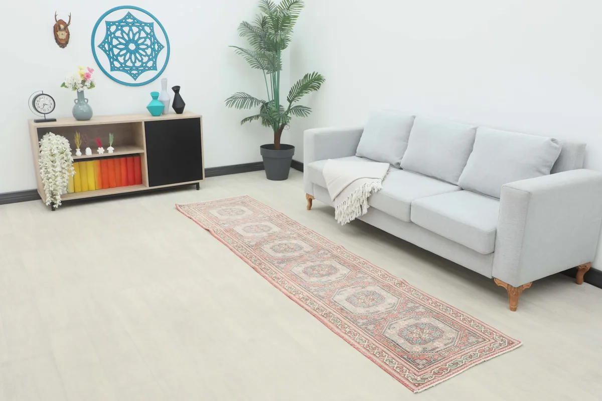 Vintage runner rug in a modern living space with a gray sofa and plant, showing its scale