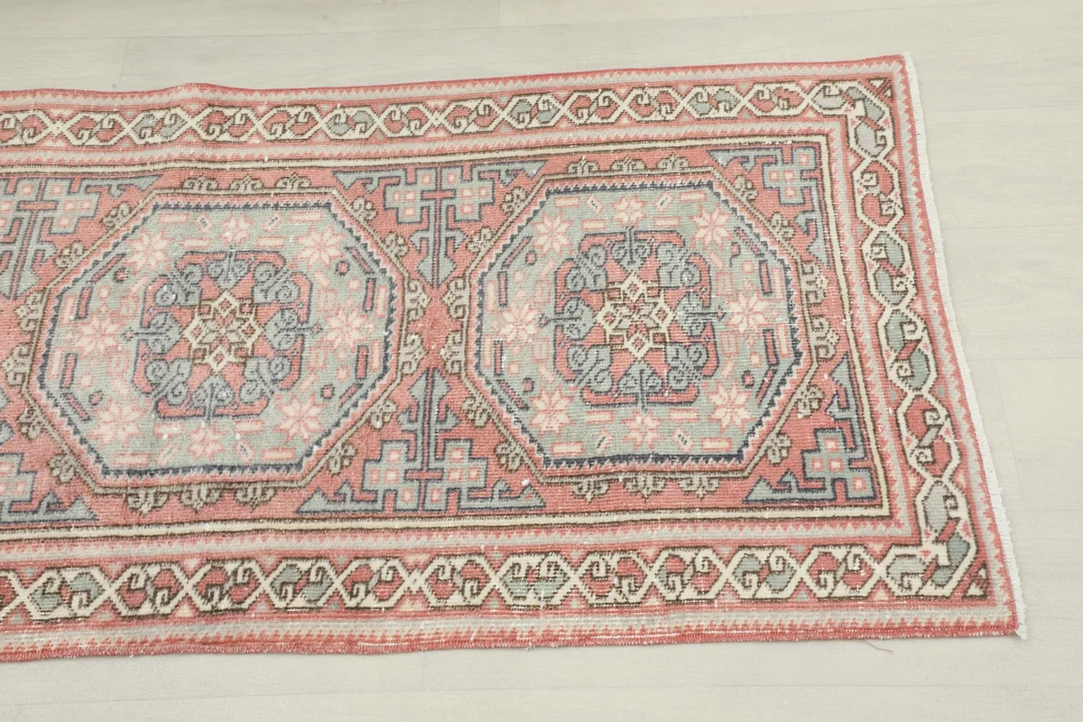 Close-up of the geometric medallion pattern and rust, gray, and blue colors of the rug