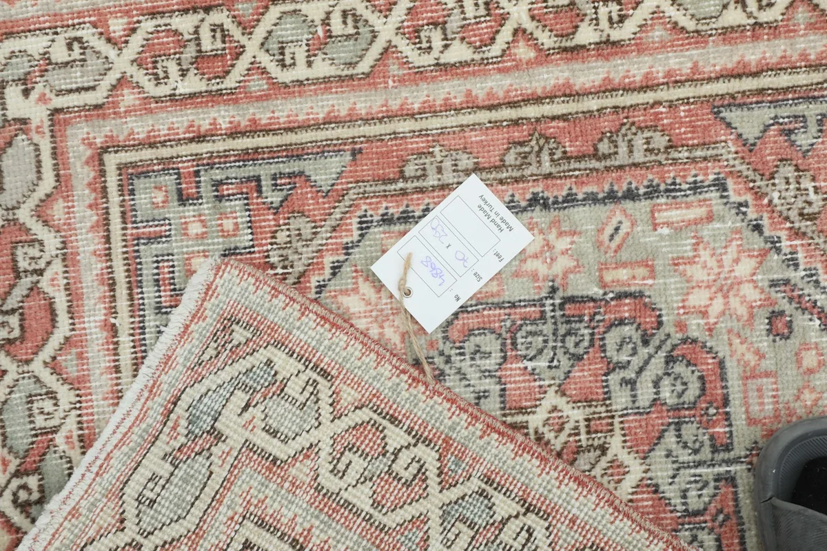 View of the rug's backing and a small tag, showing the craftsmanship and material