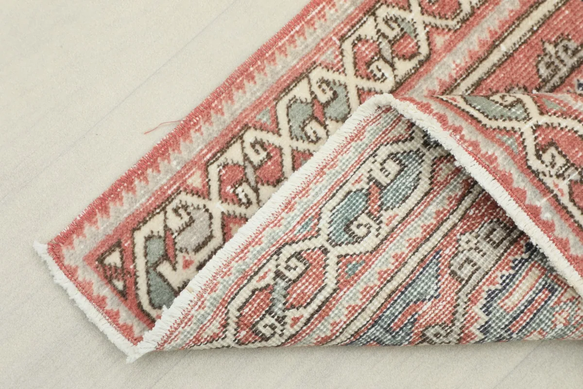 Folded section of the rug, showing the reverse side and the hand-knotted wool pile on cotton foundation
