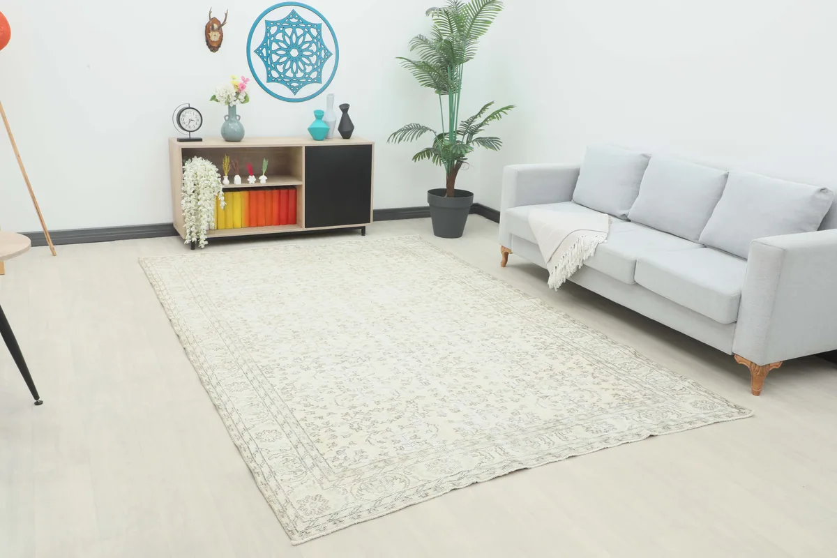 Cream Floral Anatolian Rug in a living room setting with a light gray couch and wooden cabinet