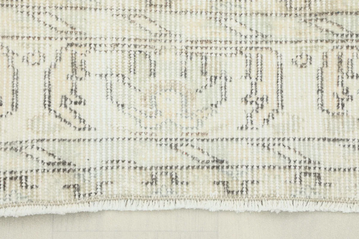 Close-up view of the Cream Floral Anatolian Rug's border design, showing distressed gray and beige tones