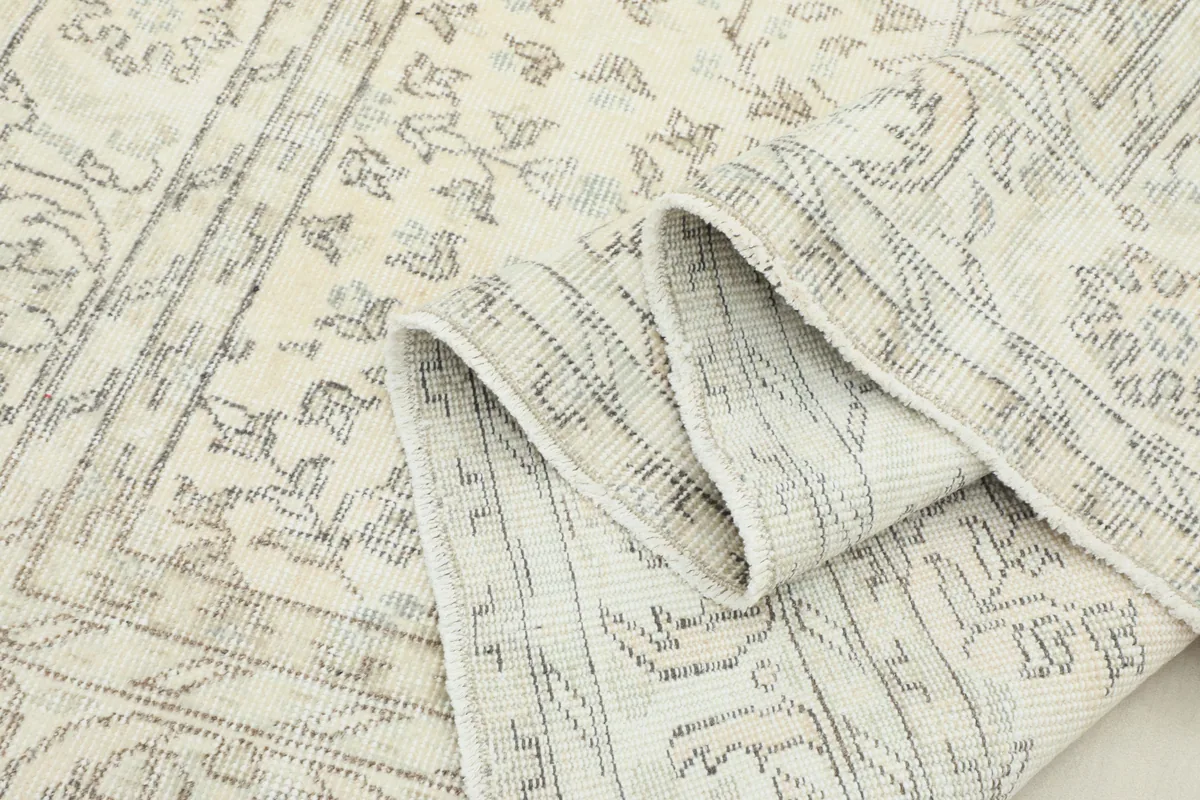 Cream Floral Anatolian Rug folded to show the pile and the detailed craftsmanship of the vintage piece