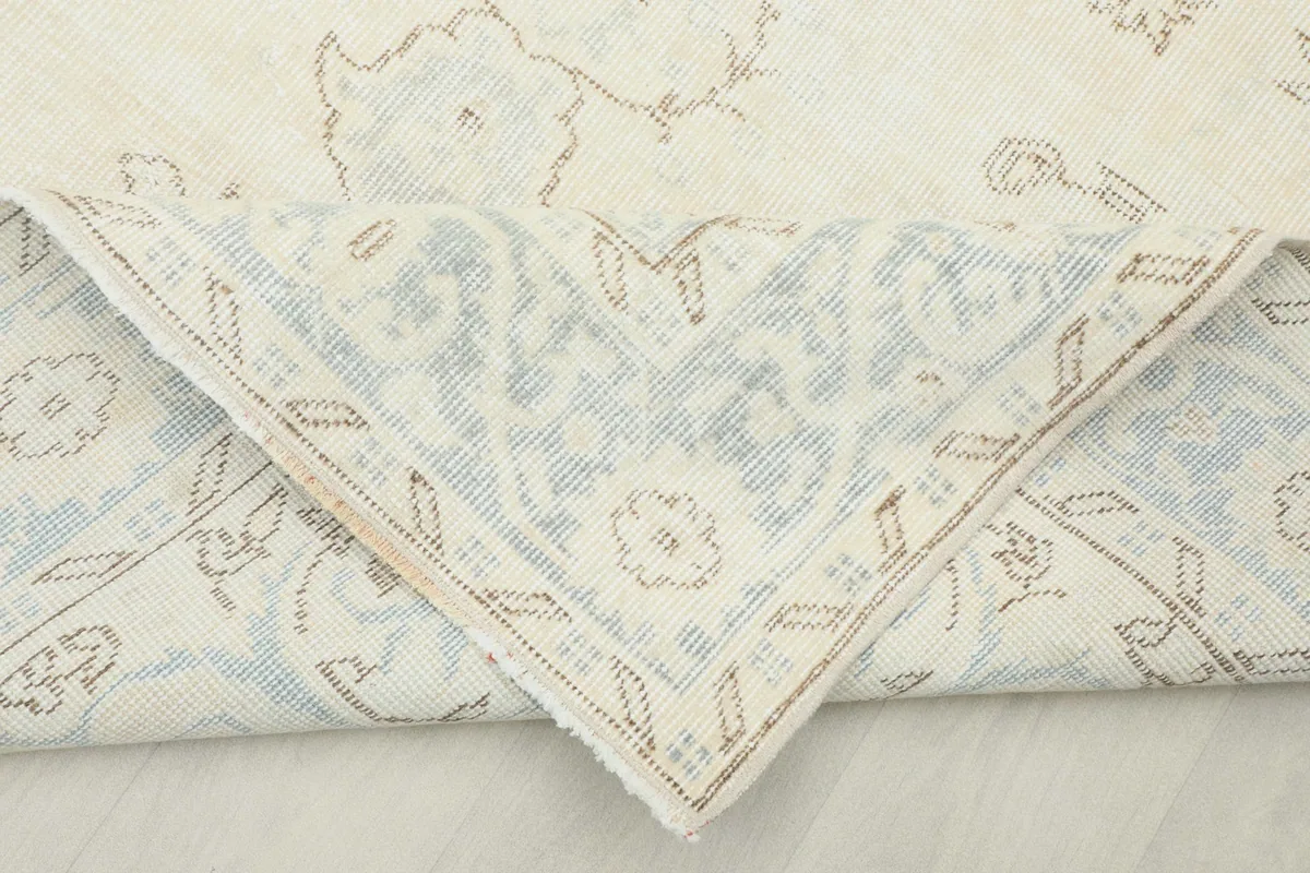 Underside view of a folded corner, revealing the cotton foundation and hand-knotted structure.