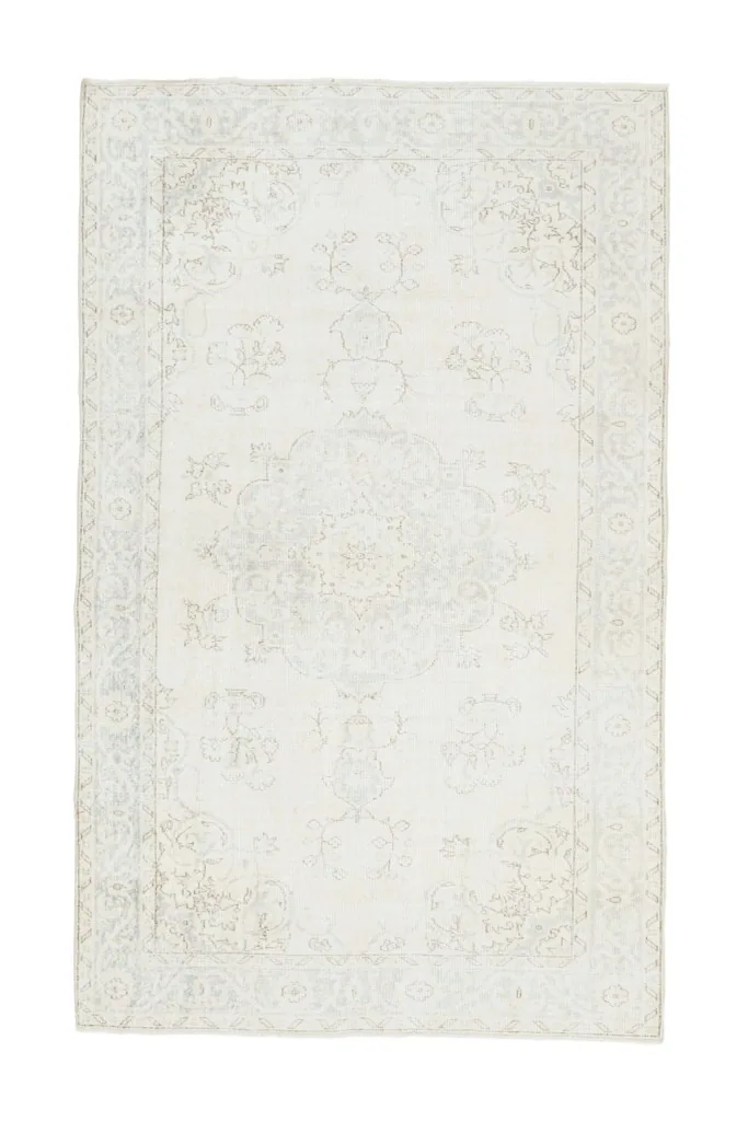 Full overhead view of the ivory and blue vintage Anatolian rug on a white background.