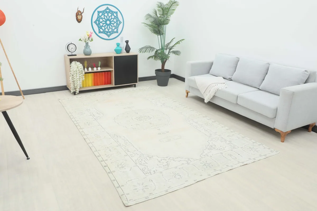 Ivory vintage rug displayed in a living room setting with a light gray sofa and modern furniture