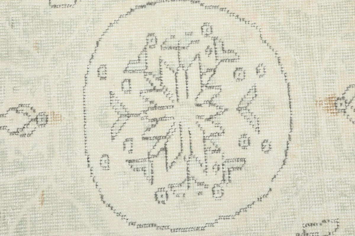 Macro view of the intricate geometric pattern within the central medallion of the hand-knotted rug