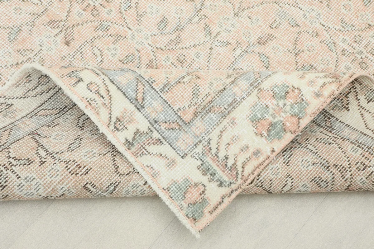 Corner of the rug folded back, revealing the wool pile and cotton foundation