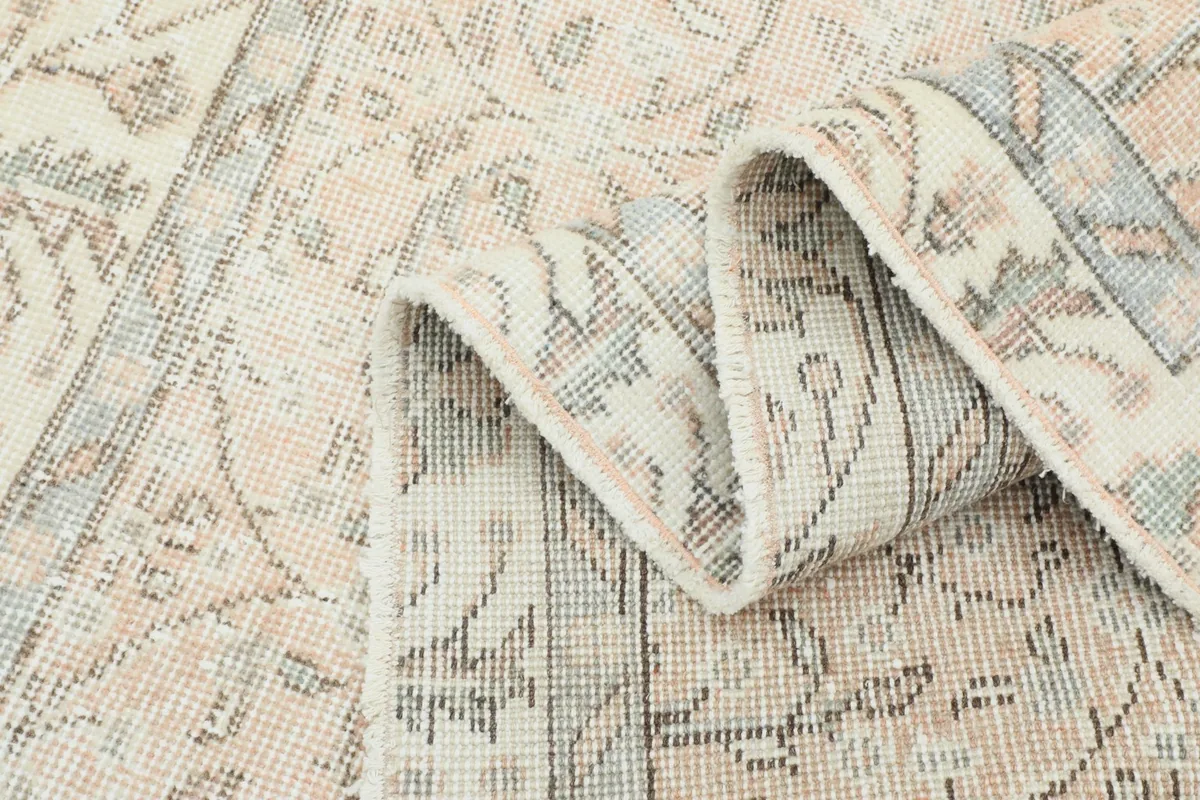 Woven texture and subtle variations in the pile are visible in a folded section of the rug