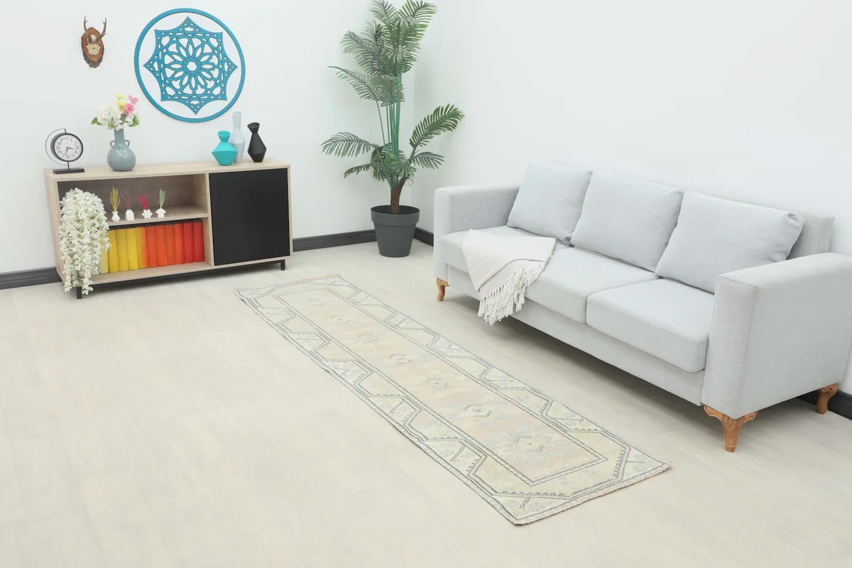 Vintage runner rug in a living room setting, showcasing its length and scale next to a sofa.