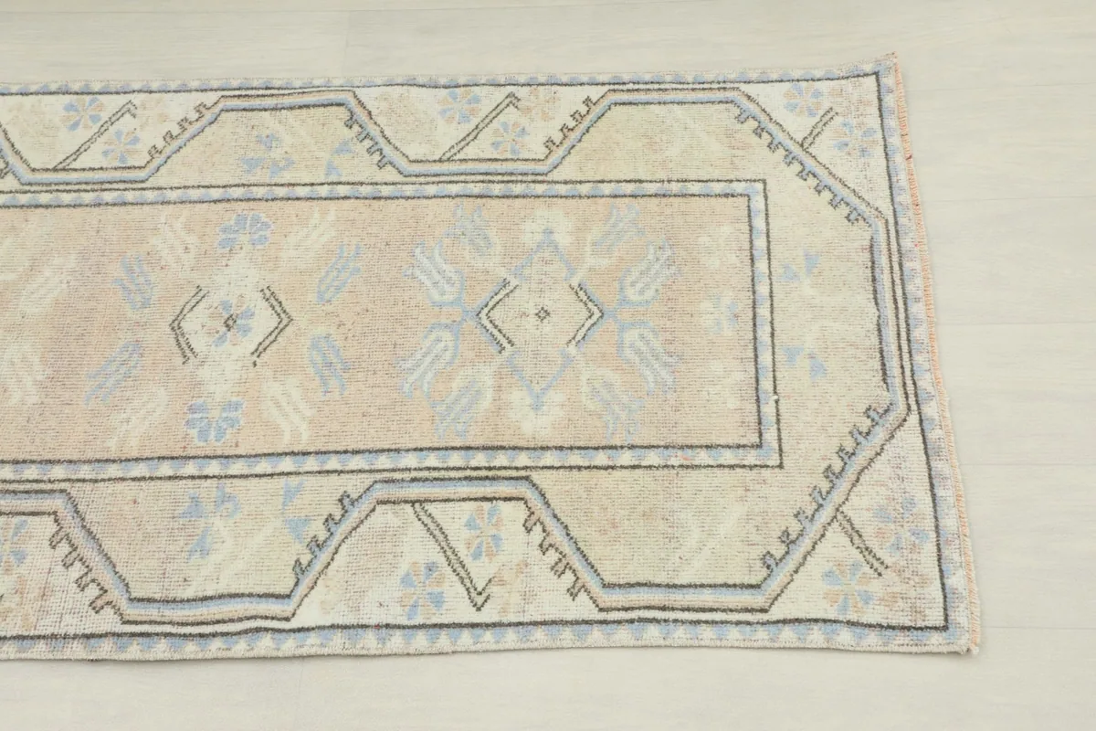 Close-up detail of the runner's end, showing the geometric border design and field motifs.