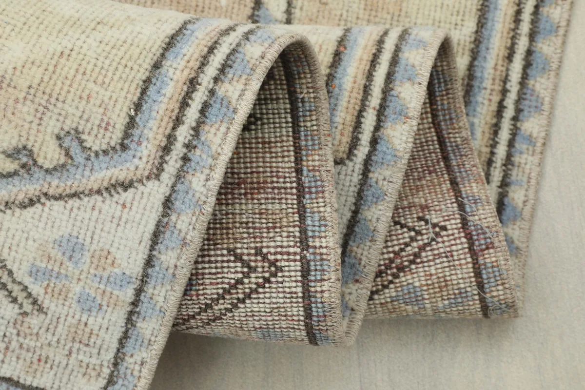 Detailed shot of the rug folded, illustrating the flexibility and thickness of the vintage runner.