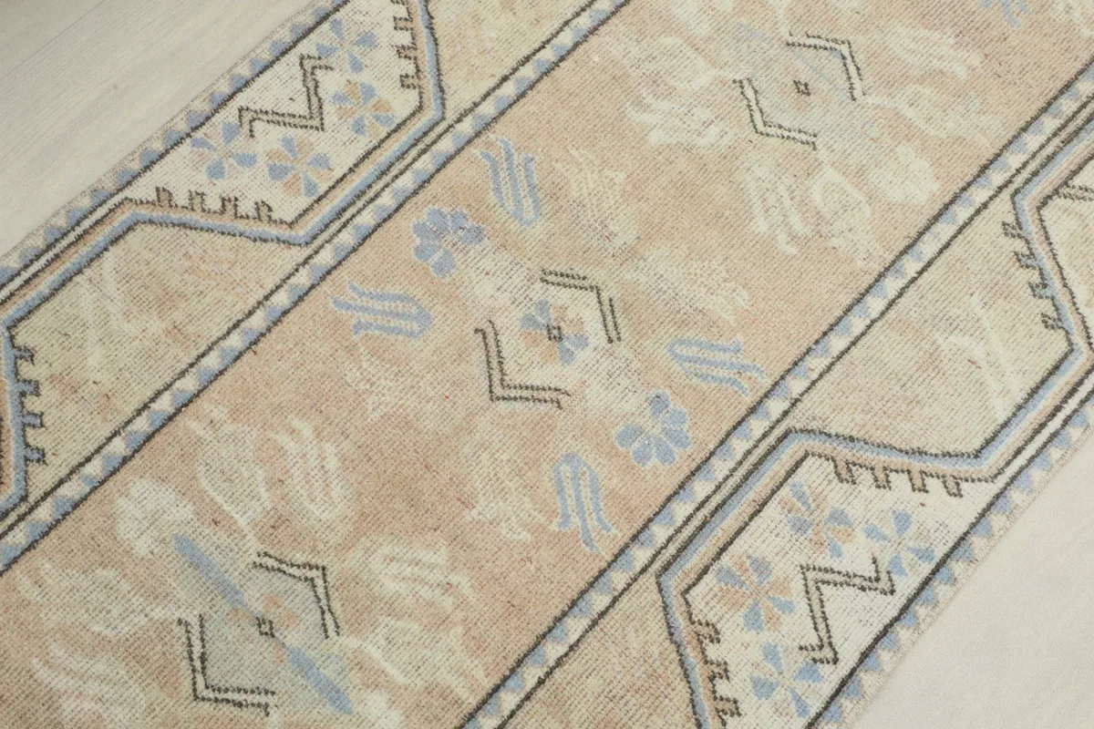 Overhead view of the central section of the runner, focusing on the beige field and blue-rose motifs.
