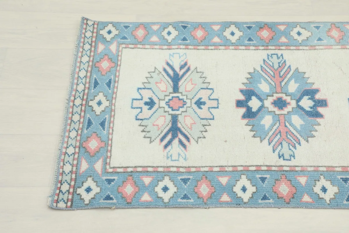 Detailed view of the other end of the hand-knotted runner, showing the geometric patterns