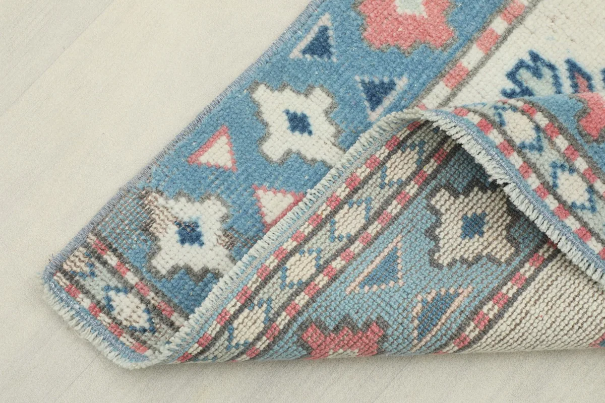 View of the rug's corner folded back, revealing the wool pile and cotton foundation