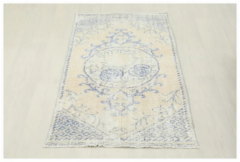 Full top view of the beige and blue vintage Anatolian rug on a white background