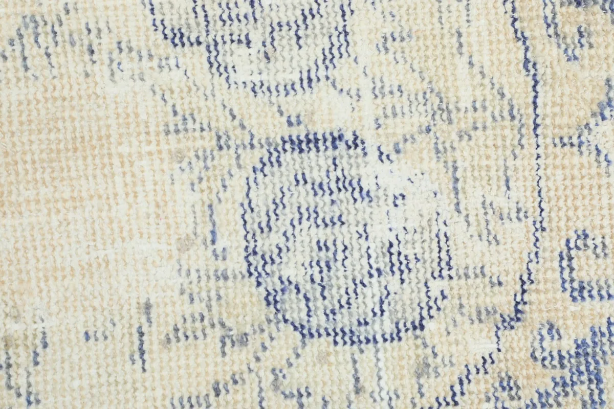 Macro shot of the rug's low wool pile, showing the texture and hand-knotted details