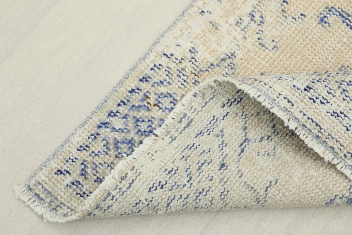 View of the rug's reverse side, revealing the cotton foundation and knotting structure
