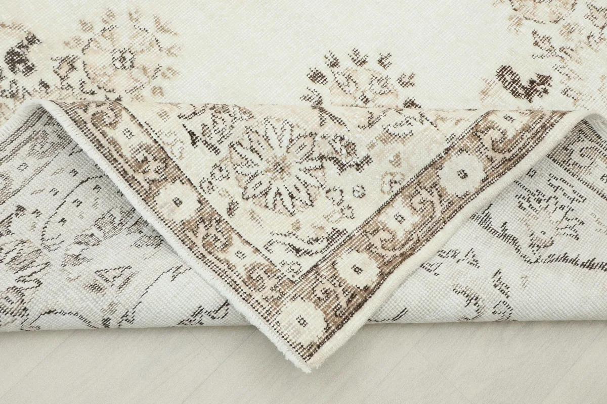 Rug corner folded back to show the cotton foundation and the reverse side of the knotting
