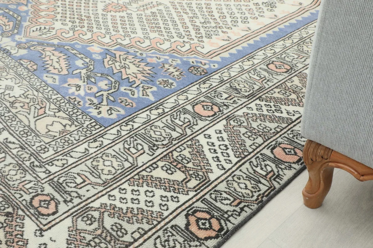 Rug in a room setting, showing its edge next to a furniture leg
