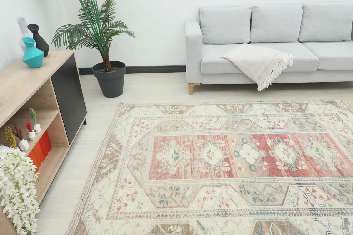 Angle view of the 6x8 vintage Anatolian rug placed in a living room with a gray sofa