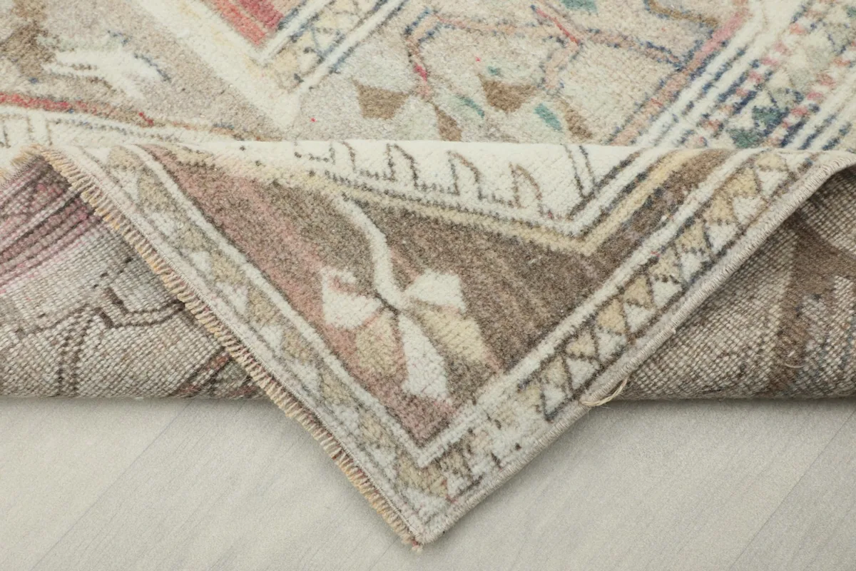 Corner of the hand-knotted vintage rug folded to show the backing and construction