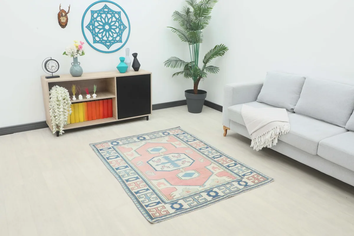 Small 4x5 pink and blue vintage rug in a modern living room setting