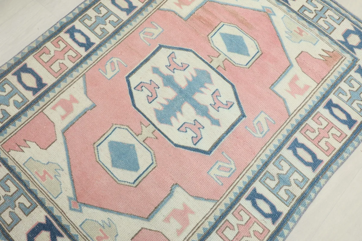 Overhead detail of the central medallion and surrounding motifs in pink, blue, and ivory
