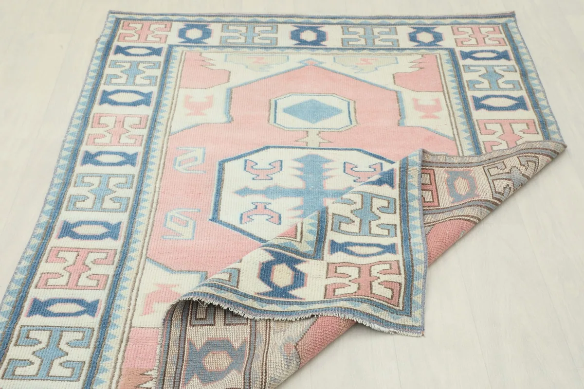 The rug folded to showcase the back and the hand-knotted construction