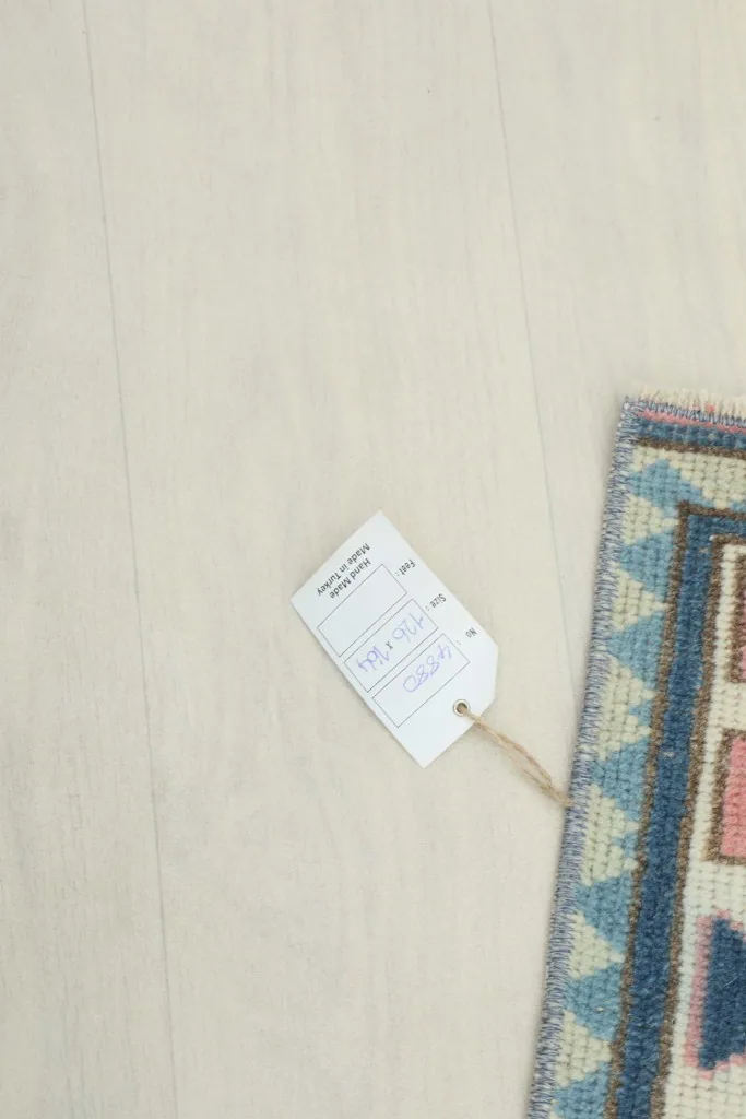 Partial view of the rug with a product tag, indicating its unique details