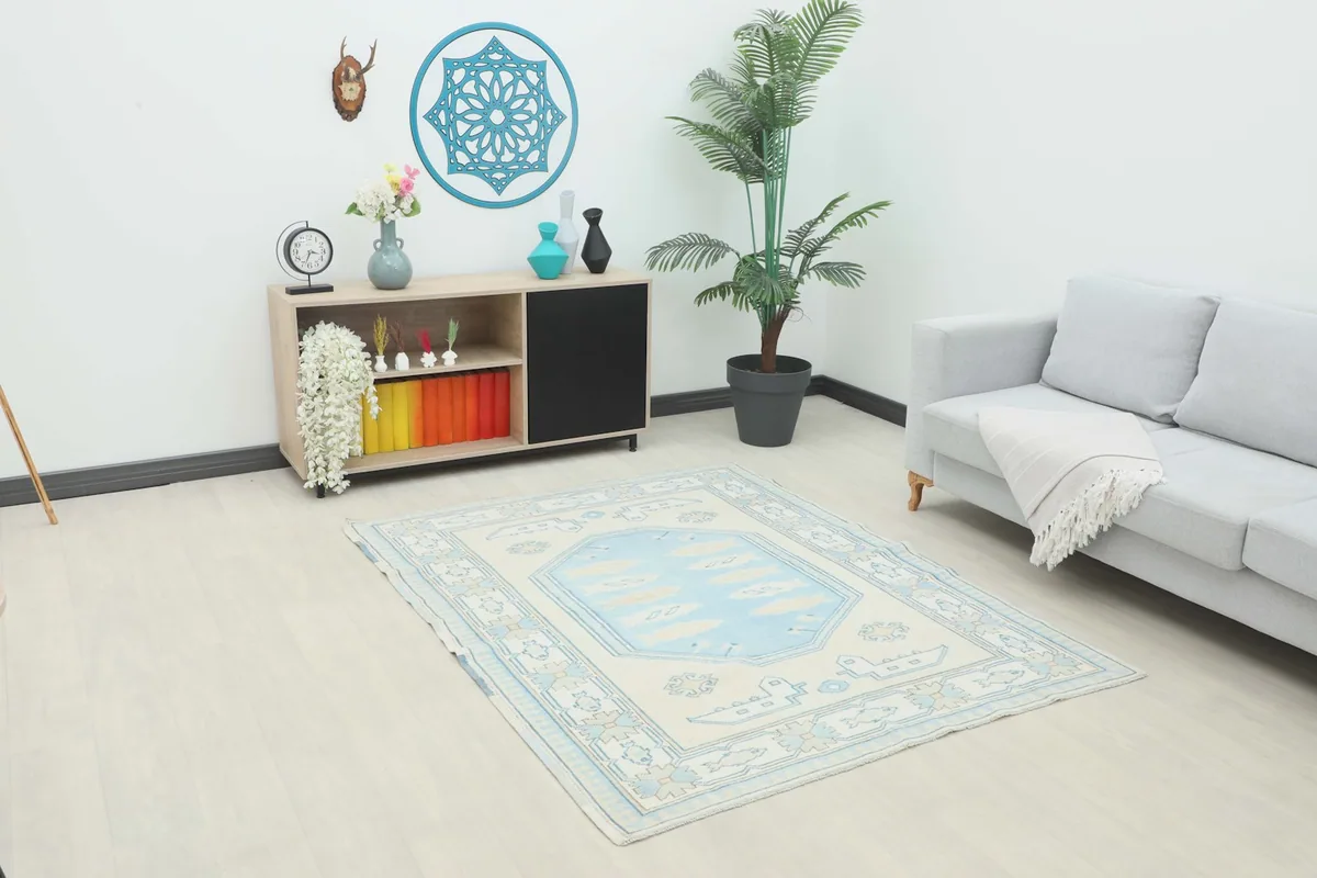 Vintage Anatolian rug displayed in a room setting with a light grey sofa and wooden cabinet