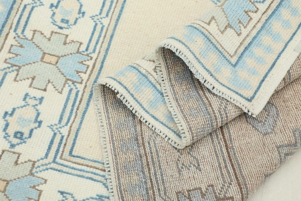 Side view of the rug, showing the low pile height and the texture of the hand-knotted wool
