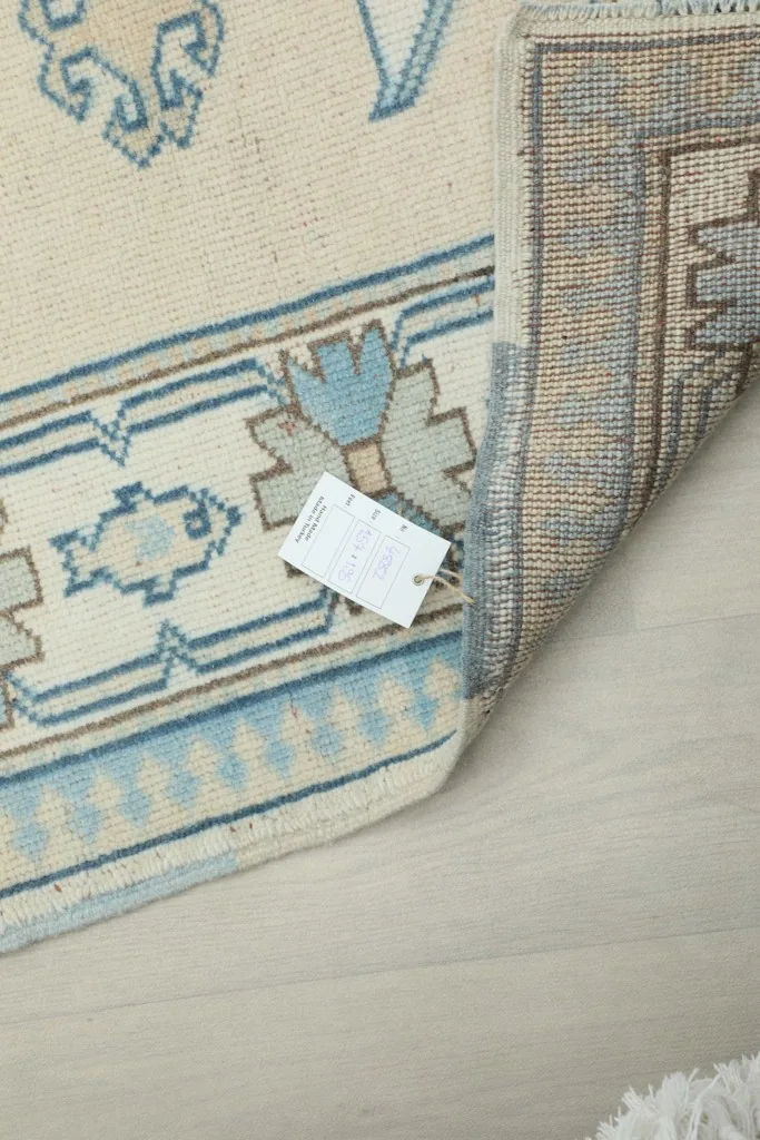Back of the rug with product tag, illustrating the quality of the hand-knotted construction