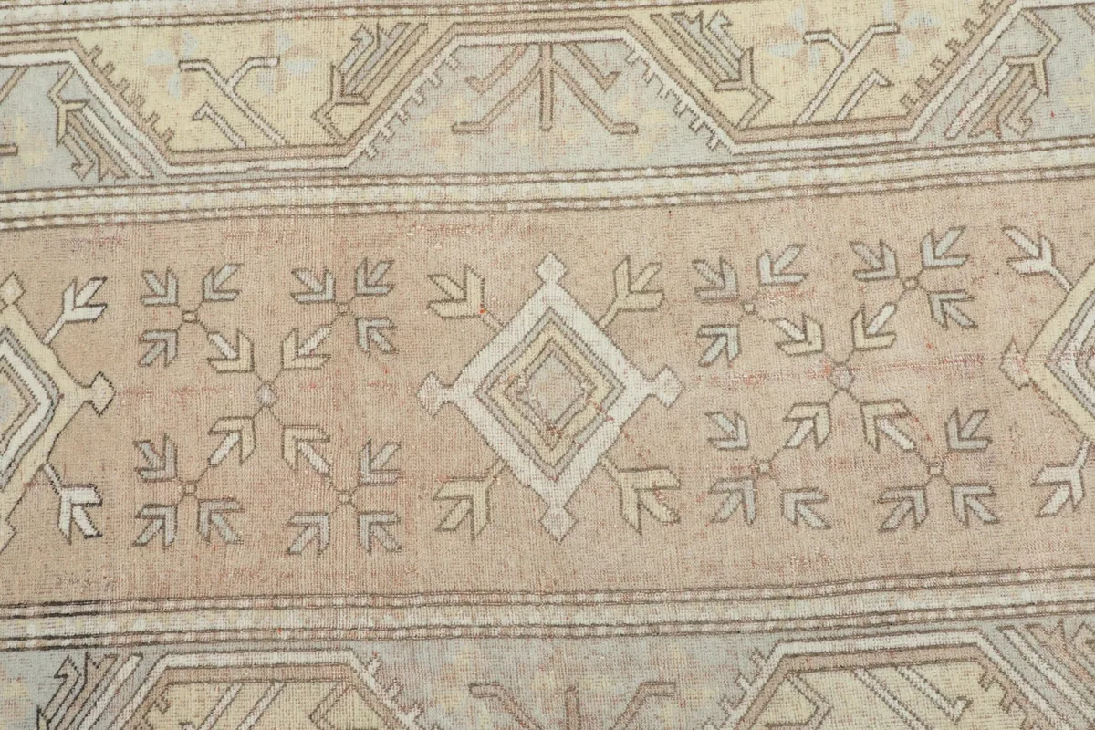 Detailed view of the central rose field and geometric motifs within the vintage rug.